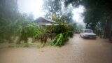 A vehicle sits next to a house, stranded in the flood waters caused by Hurricane Matthew, in Leogane, Haiti, Oct. 4, 2016. 