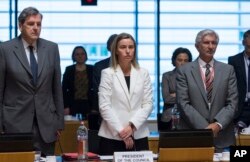 Đại diện cấp cao Liên minh châu Âu Federica Mogherini (giữa) dành một phút im lặng cho các nạn nhân vụ đắm tàu trước cuộc họp của các ngoại trưởng EU tại Luxembourg, ngày 20/4/2015.