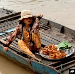 Bé gái bán bánh rán gói lá lục bình