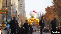 Cảnh sát đi bộ dọc theo Central Park West, phía sau là quả bóng bay khổng lồ Hello Kitty sẵn sàng cho cuộc diễu hành, ngày 22/11/2012.