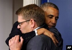 Tổng thống Obama ôm ông Jay Carney trong chuyến thăm bất ngờ tới Phòng họp báo Brady sau khi ông Carney thông báo quyết định từ nhiệm vào tháng 6