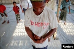 Một người Rohingya cầu nguyện với những người khác tại nhà thờ Hồi giáo tạm trong trại dành cho những người phải di dời do bạo lực, gần Sittwe.