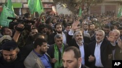 Lãnh tụ lưu vong của Hamas, ông Khaled Meshaal (trái), và Thủ tướng của Hamas ở Gaza, ông Ismail Haniyeh, vẫy tay trong lúc đi qua đường phố ở thành phố Gaza, 7/12/2012