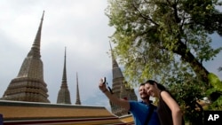 Du khách chụp ảnh lưu niệm tại chùa Wat Pho ở Bangkok, Thái Lan.