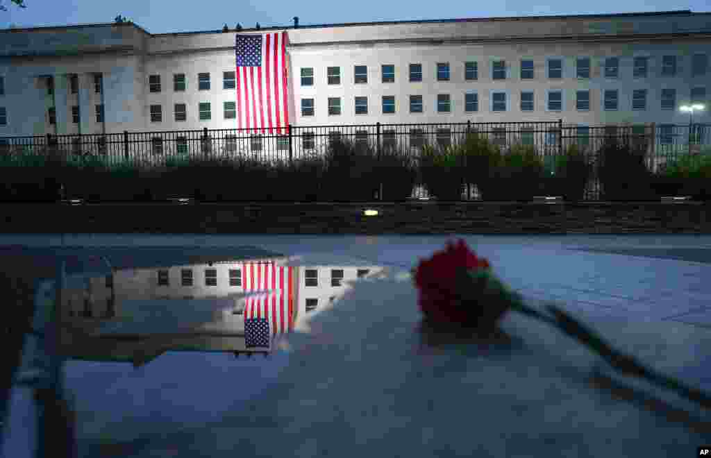 A U.S. flag is unfurled at sunrise on Sept. 11, 2018, at the Pentagon.