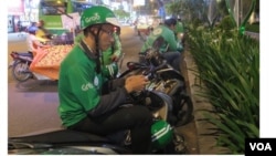 Phạm Quốc Thái đang chạy Grab. (Hình: Trích xuất từ trang web báo Thanh Niên)