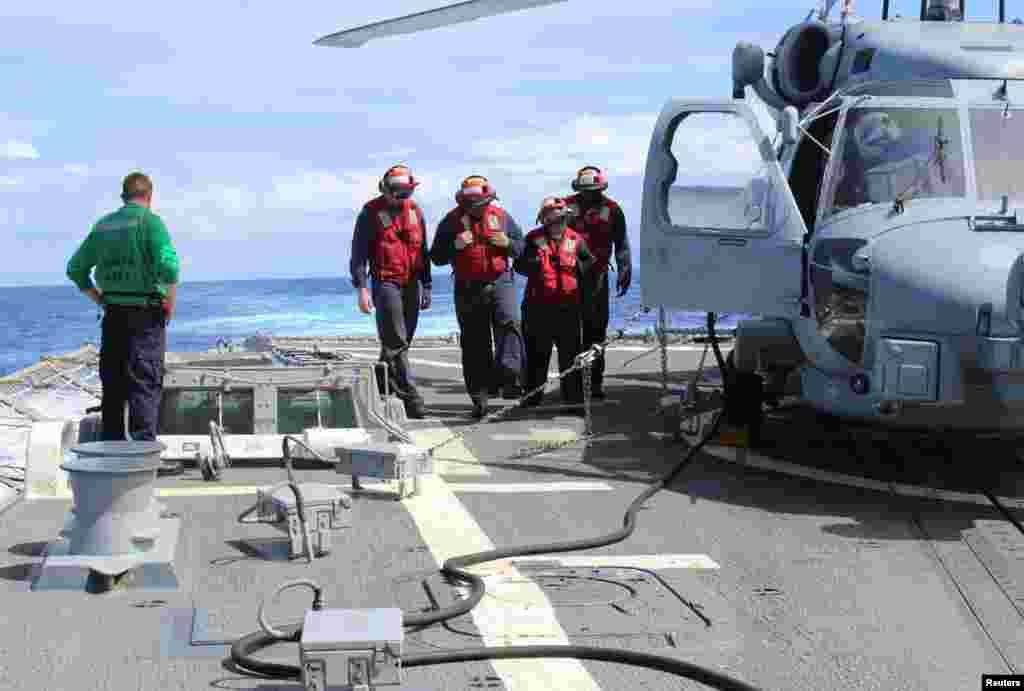 Thủy thủ Hoa Kỳ kiểm tra sàn đáp của tàu sân bay USS Kidd.