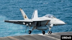 Chiến đấu cơ F/A-18F đáp xuống tàu sân bay USS George H.W. Bush (CVN 77) sau khi tiến hành các cuộc không kích chống Nhà nước Hồi giáo, 23/9/2014.