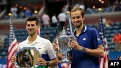 Tay vợt Novak Djokovic (trái) đang nhận giải nhì tại US Open 2021