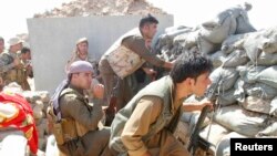 Những tình nguyện viên của lực lượng Peshmerga người Kurd đụng độ với các phần tử chủ chiến Nhà nước Hồi giáo ở thị trấn Daquq, phía nam Kirkuk, 30/9/2014. 