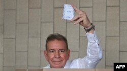 (FILES) Venezuelan opposition presidential candidate Edmundo Gonzalez Urrutia shows his ballot as he votes at the Santo Tomas de Villanueva school in Caracas during the presidential election on July 28, 2024.