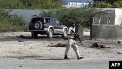 Binh sĩ Somalia bên cạnh thi thể của thường dân bị thiệt mạng trong vụ đánh bom nhắm vào sân bay Mogadishu, ngày 9/9/2010