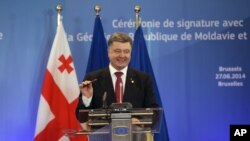 Tổng thống Ukraine Petro Poroshenko cầm cây bút sau khi ký hiệp định tại hội nghị thượng đỉnh EU ở Brussels, 27/6/14