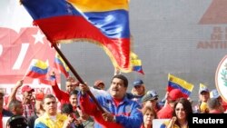 Tổng thống Venezuela Nicolas Maduro phất cờ trong cuộc tuần hành kỷ niệm cuộc cách mạng 'Caracazo'. Trong bài phát biểu tại cuộc mít-tinh, ông Maduro cho biết chính quyền của ông vừa bắt giữ một phi công Mỹ bị cáo buộc làm gián điệp.