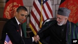 Tổng thống Hoa Kỳ Barack Obama (trái) và Tổng thống Afghanistan Hamid Karzai bắt tay trước khi ký một ký thỏa thuận đối tác chiến lược tại dinh tổng thống ở thủ đô Kabul, Afghanistan hôm 1/5/12