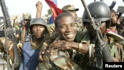 aitian National Revolutionary Liberation Front Commander-in-Chief, Guy Philippe, hugs other soldiers from the 