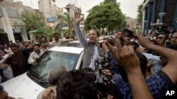 Cựu Thủ tướng Pakistan Nawaz Sharif vẫy chào những người ủng hộ khi rời 1 trạm bỏ phiếu ở Lahore, Pakistan, 11/5/2013