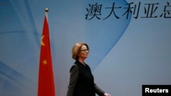 Thủ tướng Australia Julia Gillard đi ngang quốc kỳ của Trung Quốc khi bà đến dự bữa ăn trưa của Diễn đàn Kinh tế và Thương mại Trung Quốc-Australia tại một khách sạn ở Bắc Kinh, ngày 9/4/2013. 