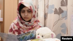 Nữ sinh Pakistan Malala Yousufzai đọc một tấm thiệp trong lúc đang được điều trị tại Bệnh viện The Queen Elizabeth ở Birmingham, Anh (ảnh của Reuters đăng ngày 8/11/2012)