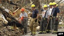 Nhân viên cứu hộ tìm kiếm những người còn mất tích sau trận bão tại thành phố Joplin, bang Missouri, 28/5/2011