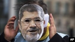 Người biểu tình đeo mặt nạ Tổng thống Ai Cập Mohammed Morsi trong cuộc biểu tình tại Berlin, Đức, ngày 30/1/2013.