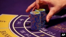 Nhà cái đếm các thẻ đánh bạc trên bàn bài baccarat trong một sòng bài tại khách sạn Sheraton Macao