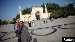 Người Uighur đi bộ bên ngoài một nhà thờ Hồi giáo ở Kashgar, Tân Cương.