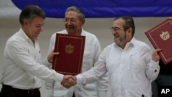 Tổng thống Colombia Juan Manuel Santos (trái) và thủ lĩnh của lực lượng nổi dậy FARC Timoleon Jimenezshake bắt tay trong buổi lễ ký kết thỏa thuận ngừng bắn và giải giới ở Havana, Cuba, ngày 23 tháng 6 năm 2016. 