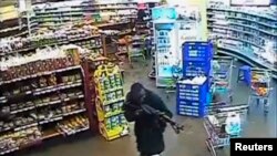 A gunman aims his rifle inside a store during an attack on the Westgate shopping mall in this still frame taken from video footage by security cameras inside the mall in Nairobi and released to Reuters on Oct. 17, 2013. 