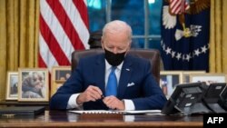 Tư liệu: TT Hoa Kỳ Joe Biden ký một loạt sắc lệnh hành pháp liên quan tới vấn đề di trú và nhập cư tại Phòng Bầu dục ở thủ đô Washington, ngày 2/2/2021. (Photo by SAUL LOEB / AFP)