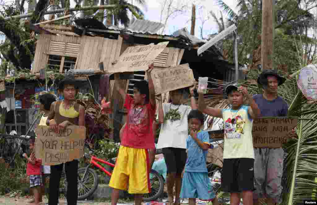 Trẻ em Philippines cầm bảng kêu gọi sự giúp đỡ dọc theo con đường cao tốc tại thị trấn Tabogon trong tỉnh Cebu, miền Trung Philippines, ngày 11/11/2013.