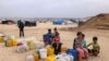 Displaced Palestinian children wait by containers for water supply at their tent camp in Rafah in the southern Gaza Strip on April 26, 2024 amid the ongoing conflict between Israel and the Palestinian militant group Hamas. (Photo by MOHAMMED ABED / AFP)