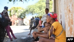 TOPSHOT - Families take to the streets to escape the gangs in Solino, a neighborhood of Port-au-Prince, Haiti, January 18, 2024.