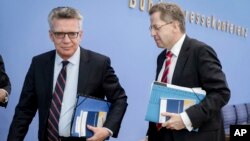 Bộ trưởng Nội vụ Đức Thomas de Maiziere, trái, và ông Hans-George Maassen, đứng đầu cơ quan tình báo quốc nội Đức rời phòng họp báo ngày 4/7/2017 tại Berlin.