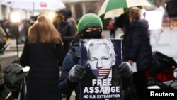 Người ủng hộ ông Julian Assange mang hình ảnh ông đứng trước toà án hình sự ở London, Anh, vào ngày 41/2021. 