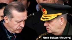 Thủ tướng Thổ Nhĩ Kỳ Recep Tayyip Erdogan (trái) nói chuyện với cựu tư lệnh quân đội Ilker Basbug trong một đám tang ở Ankara 28/2/2010