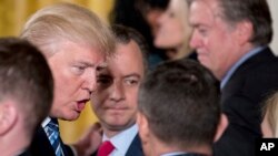 Tổng thống Mỹ Donald Trump, trái, và Chánh Văn phòng Tòa Bạch Ốc Reince Priebus, giữa, trong một buổi lễ tại Phòng Đông của Tòa Bạch Ốc, 22/1/2017.