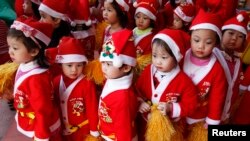 Trẻ em trong trang phục ông già Noel xếp hàng tại một trường mầm non ở Hà Nội.